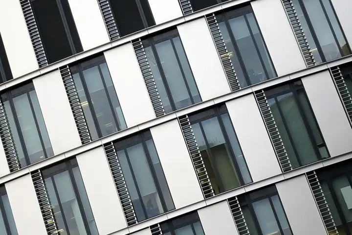 Düzenli pencereleriyle modern bir ofis binasının cephesi